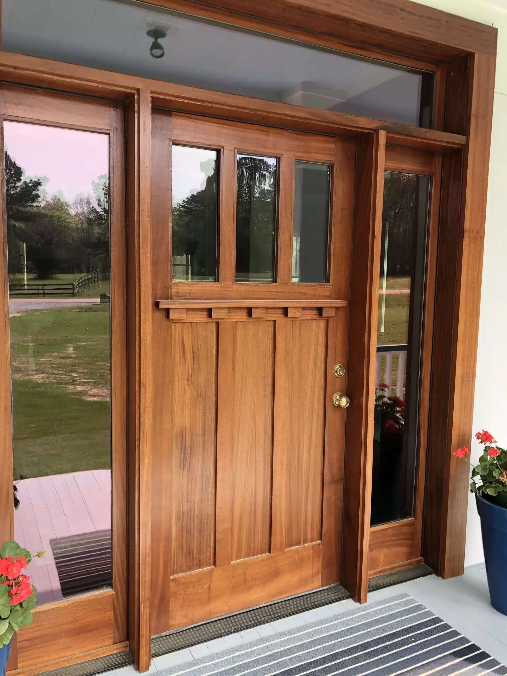 Craftsman-style wood entry door protected under a covered porch