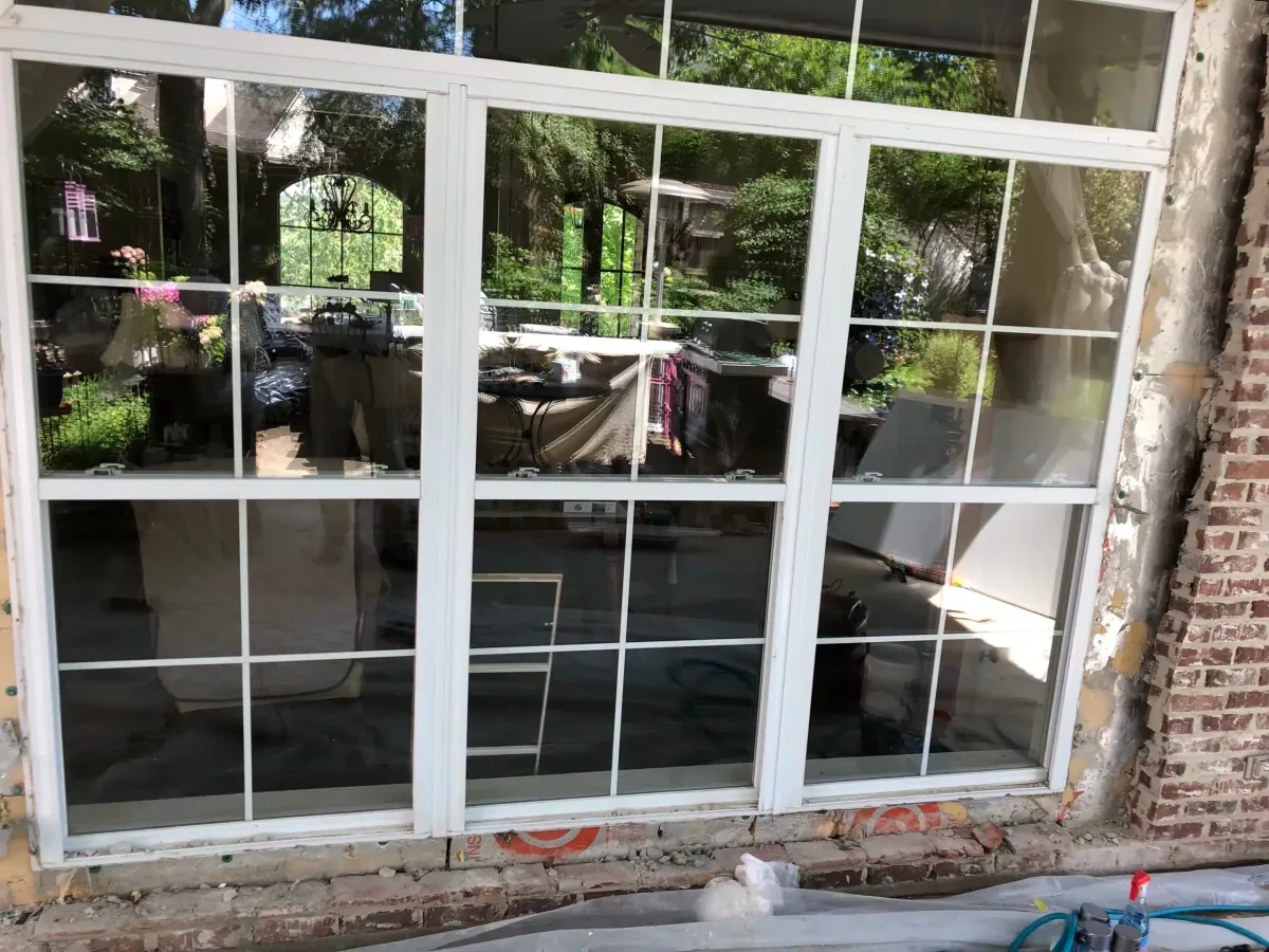 New white grid windows installed in a brick wall on a covered patio