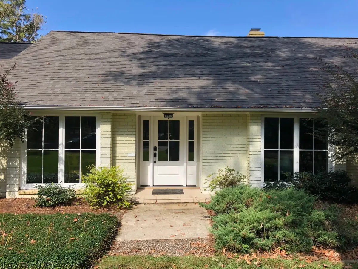 Front view of the older home with new white windows and entry door