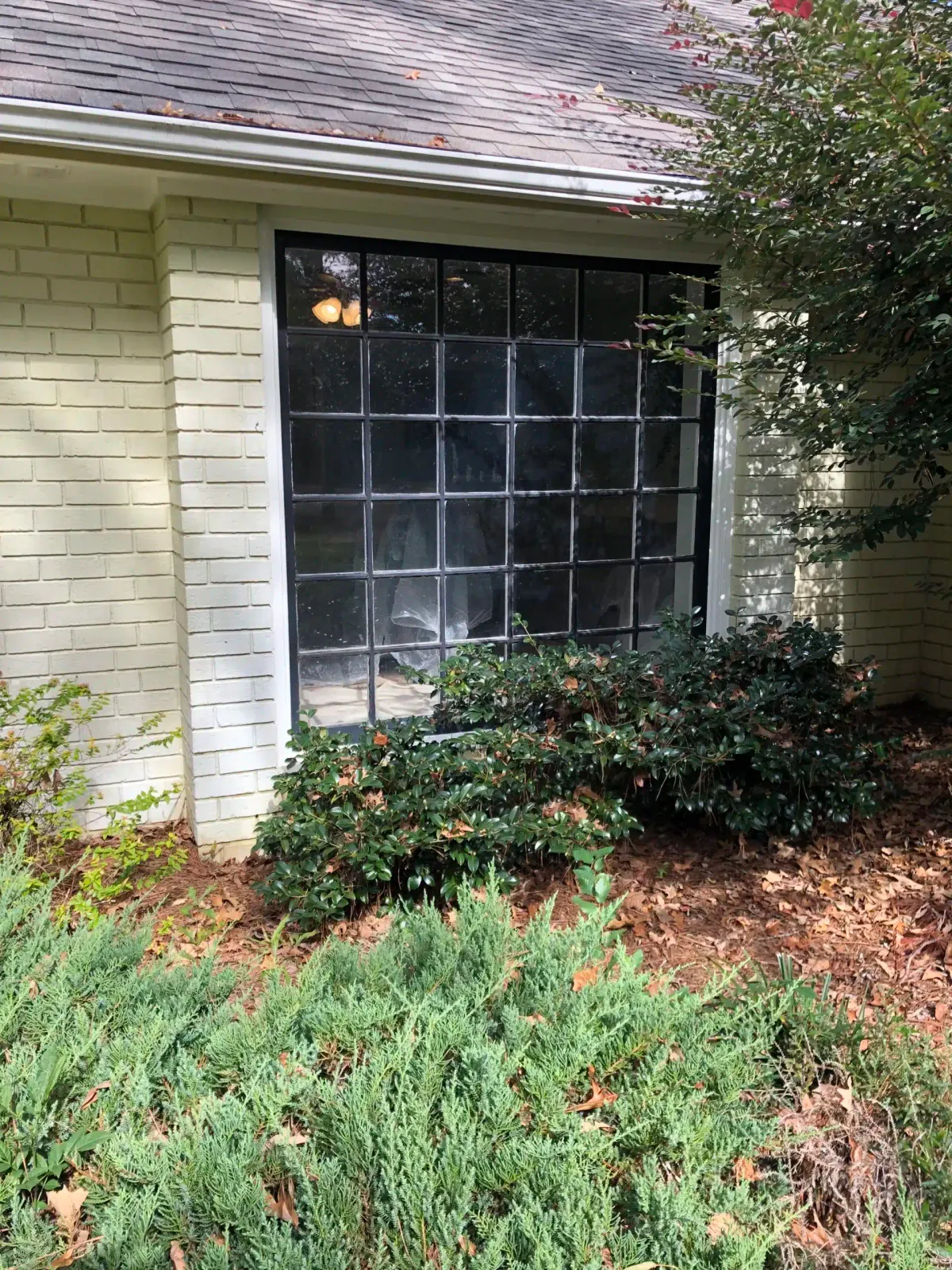 Older painted-brick home with an old divided-light window