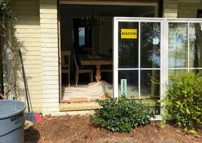 New Marvin sliding glass door being installed on a painted-brick home
